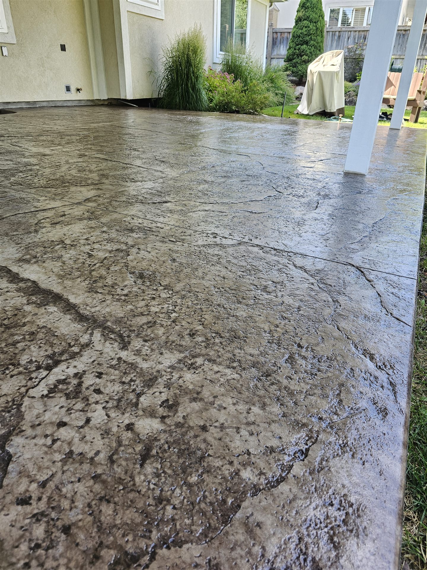 Freshly sealed wide stamped concrete patio slab