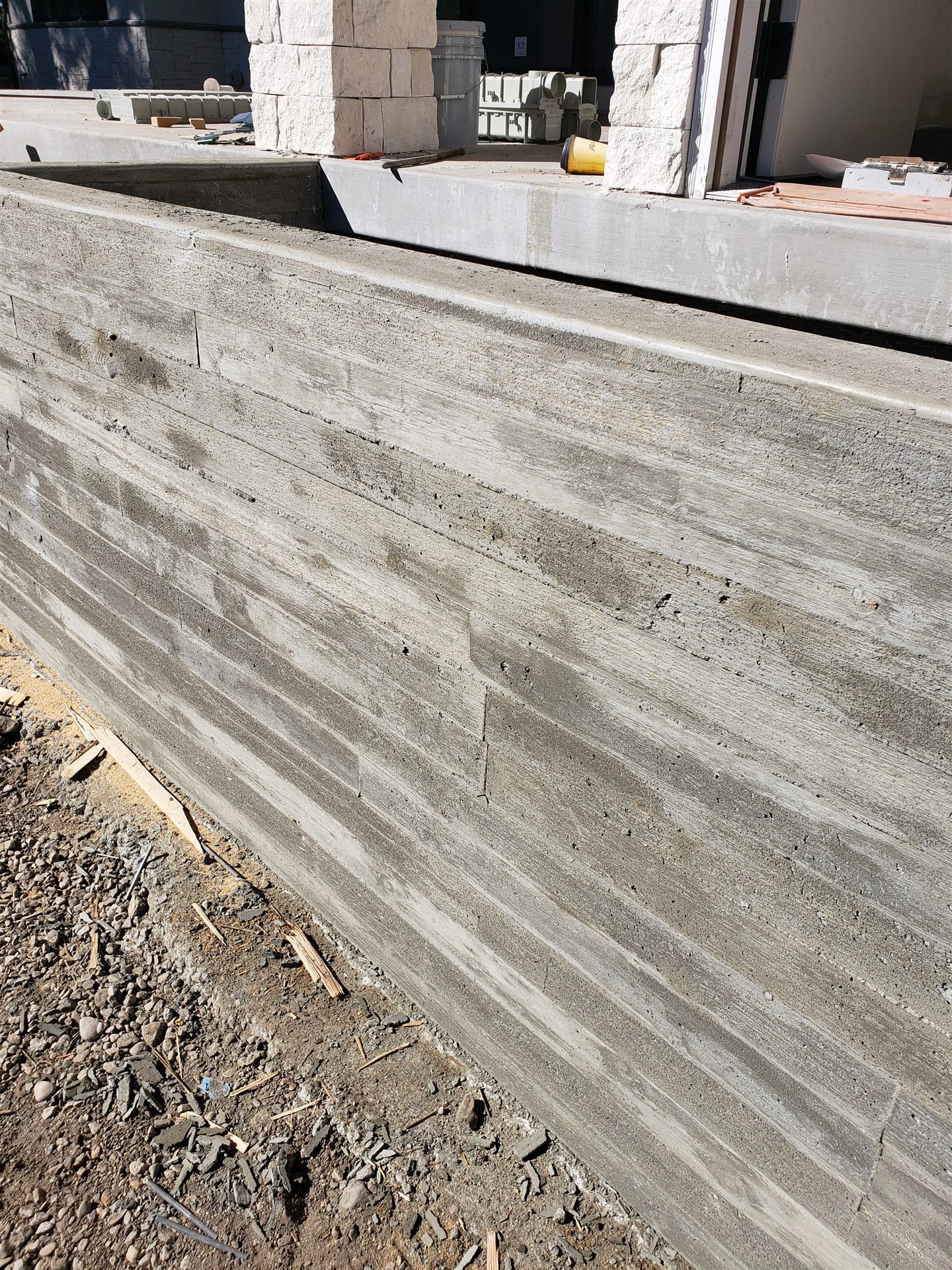 Board-form concrete retaining wall with wood-grain texture